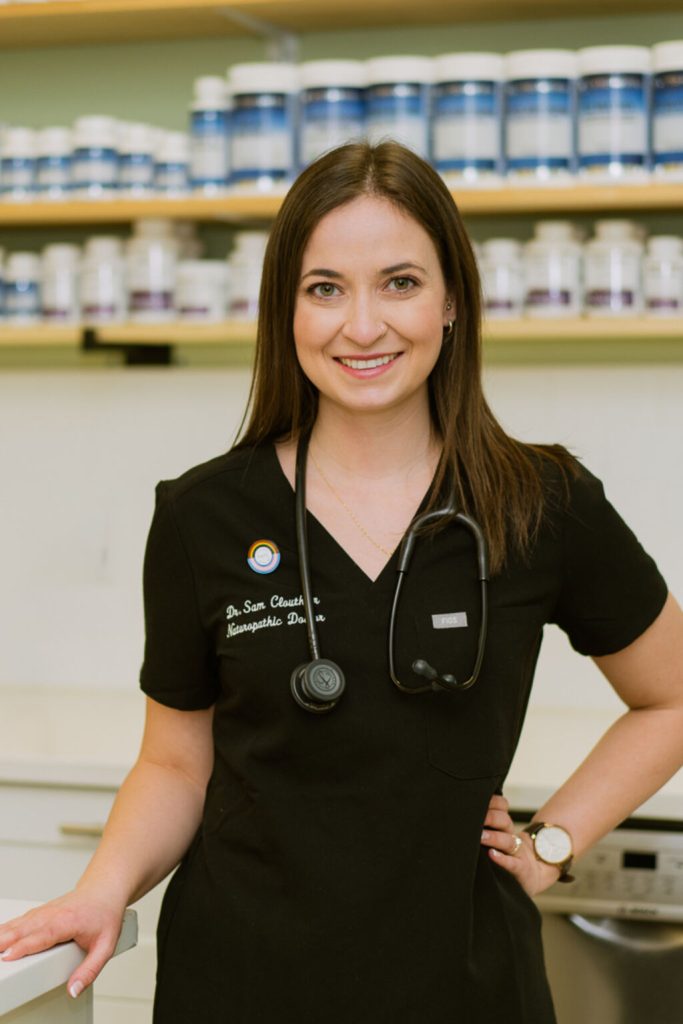 dr. sam clouthier naturopathic doctor in fort mcmurray at juniper clinic in front of supplement dispensary