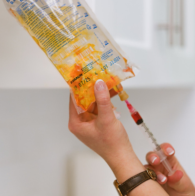juniper naturopathic clinic intravenous therapy hands injecting substance into IV bag